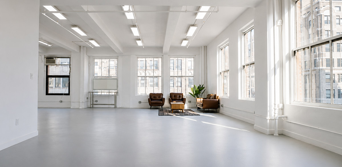 Wide Midtown Manhattan studio interior with large windows and a city view, near Penn Station in the Garment District