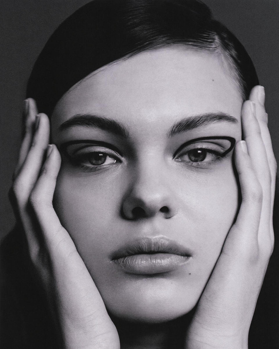 Black-and-white beauty close-up portrait with hands framing the face