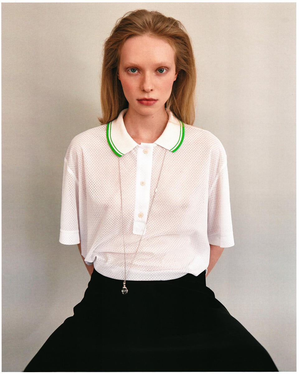 Commercial fashion portrait of a model in a white shirt and black skirt against a light studio background