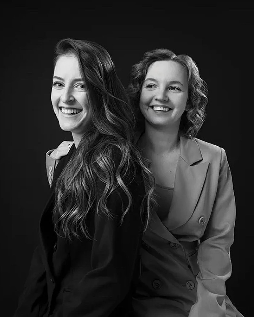 Black-and-white portrait of two women seated together in a studio