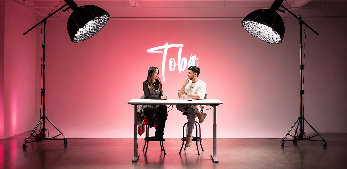 Two-person video talk setup with a pink backdrop and studio lights inside Match Studios NYC