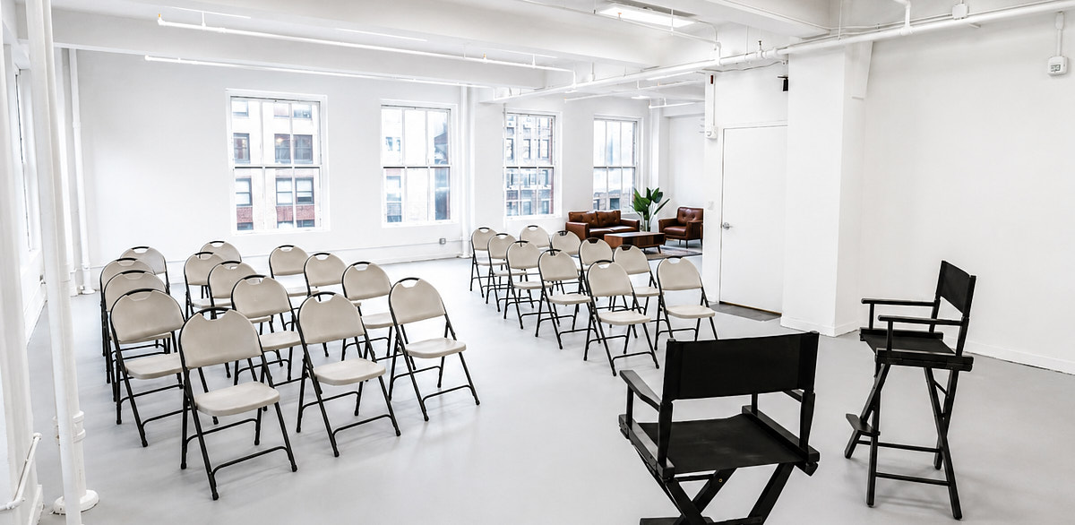 Workshop-style seating and production setup in a bright Midtown studio arranged for a team offsite or planning day