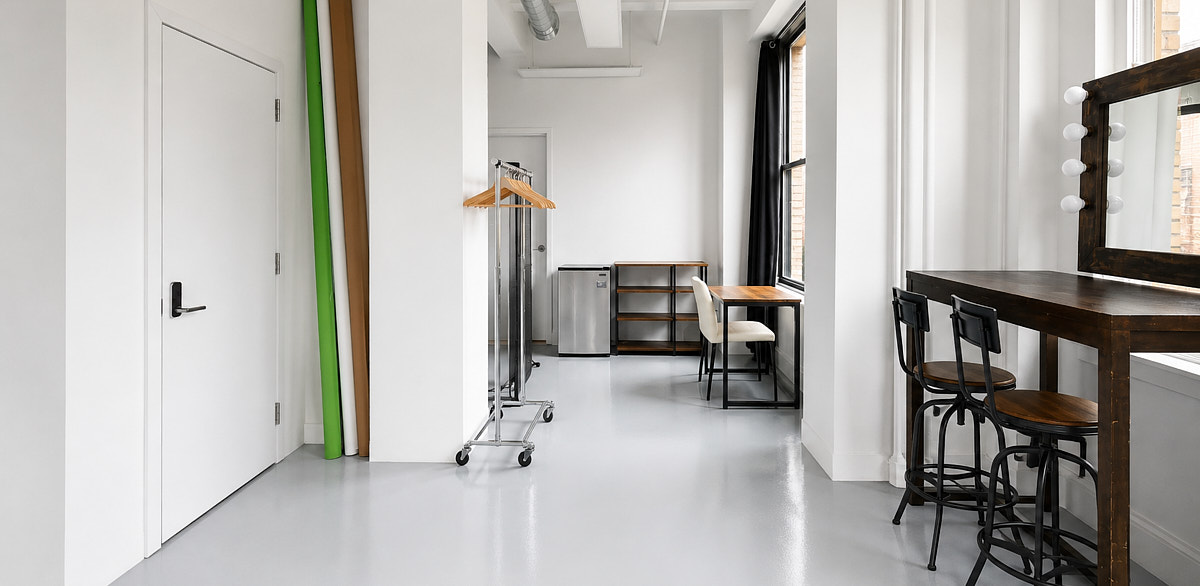 Sunlit Midtown photo studio with white floors and large windows, the kind of mid-range NYC rental compared in this pricing guide