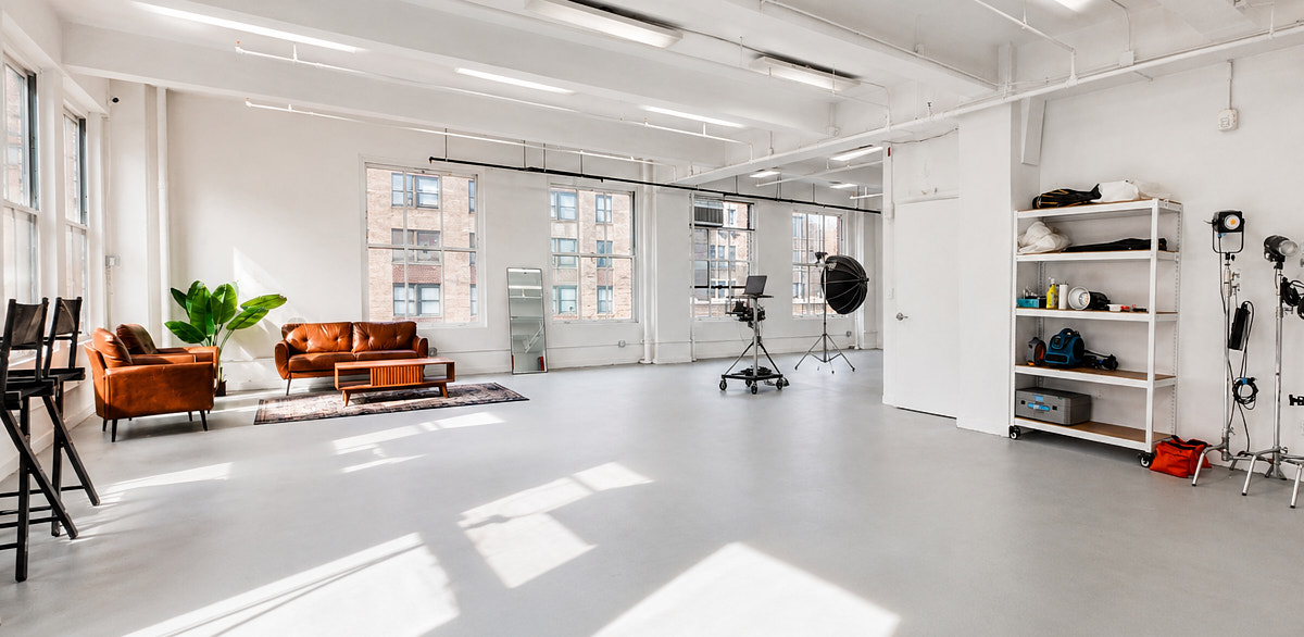 Wide studio detail view with lounge seating, open production floor, and bright natural light in Match Studios NYC